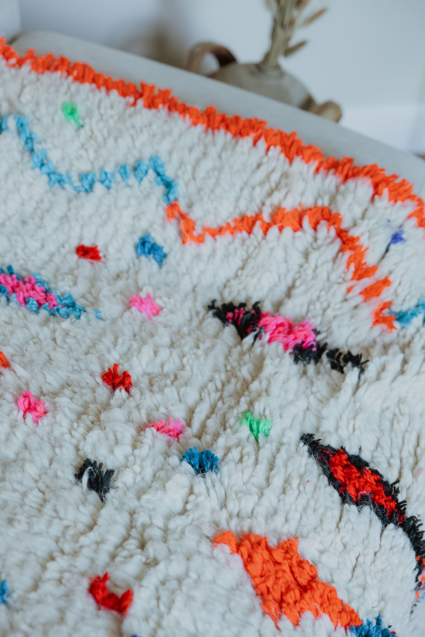 tapis enfant chambre laine Détail de la bordure orange fluo d'un tapis berbère Azilal multicolore